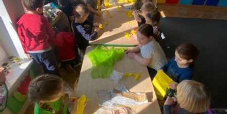 Powiększ grafikę: Dzieci z grupy Słoneczka siedzą przy stolikach wykonują prace plastyczne z bibuły.