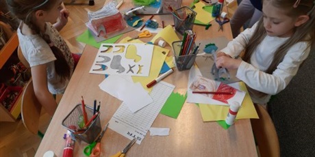 Powiększ grafikę: Dzieci z grupy Słoneczek siedzą przy stolikach w sali wykonują zwierzątka z papieru