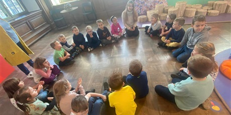 Powiększ grafikę: Dzieci z grupy Słoneczek siedzą w kole na podłodze. W tle meble muzeum .